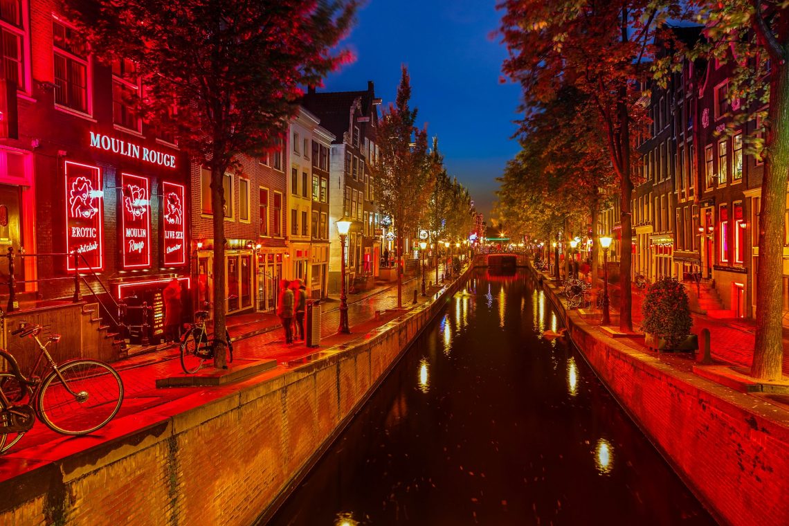 barrio rojo de amsterdam famoso ya que todas sus luces por la noche son rojas, canal con bicicletas y bares a los lados
