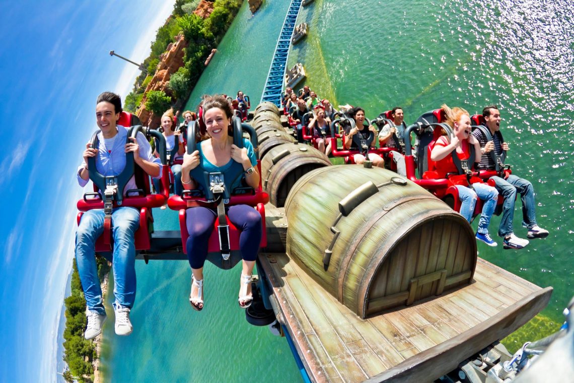 atracción de montaña rusa en la que van montadas 10 lineas de 4 personas cada una y sobrevuelan un estanque, están montados sobre railes