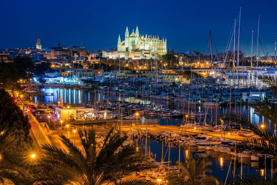 vista nocturna de Palma con puerto deportivo en primer plano y catedral iluminada al fondo