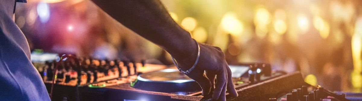 Dj-mixing-outdoor-at-beach-party-festival-with-crowd-of-people-in-background-shutterstock_670249444
