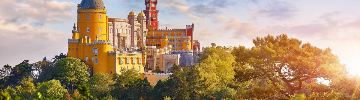 National-Palace-of-Pena-in-Sintra-near-Lisbon-Portugal.-Picturesque-landscape-with-dawn-and-green-trees.-Blue-morning-sky-with-clouds.-Image-shutterstock_1111720499_1920x1280