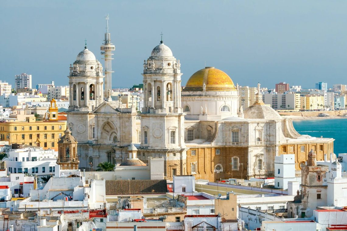 vista desde la distancia de iglesia blanca con dos grandes torres y una cupula amarilla