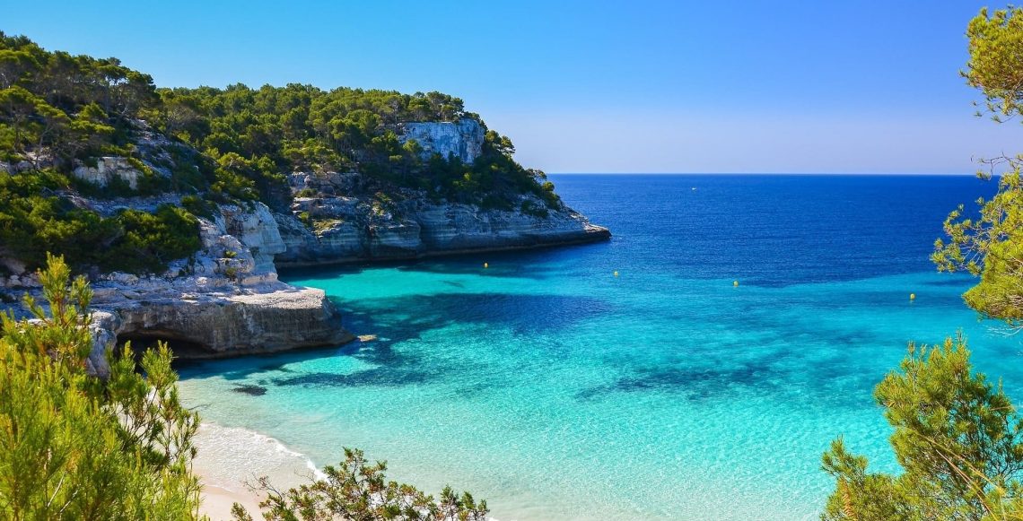 Secluded-beach-with-turquoise-sea-water-Cala-Mitjaneta-Menorca-island-Spain-shutterstock_189270002-min-1